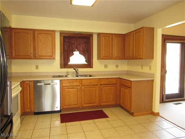 kitchen with light tile patterned floors, dishwasher, refrigerator, sink, and white range