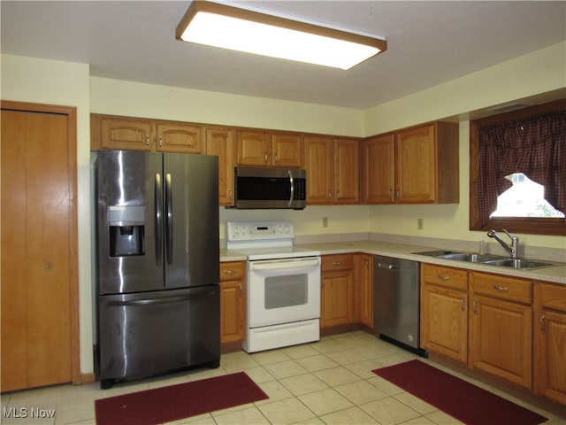 kitchen featuring appliances with stainless steel finishes, sink, and light tile patterned flooring