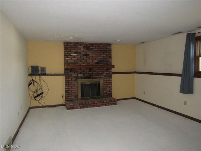 unfurnished living room featuring a fireplace and brick wall