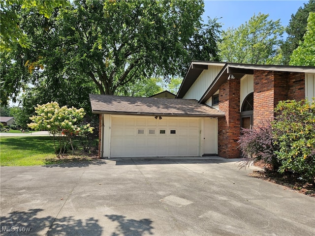 view of side of property featuring a lawn and a garage