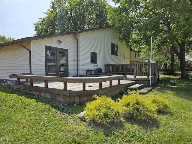 rear view of house with a lawn and a deck