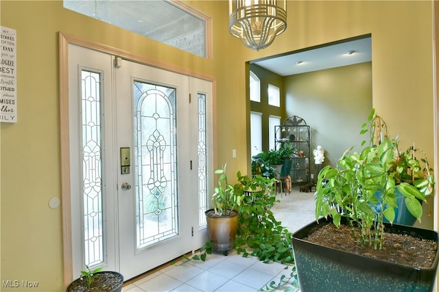 tiled foyer with a healthy amount of sunlight and a notable chandelier