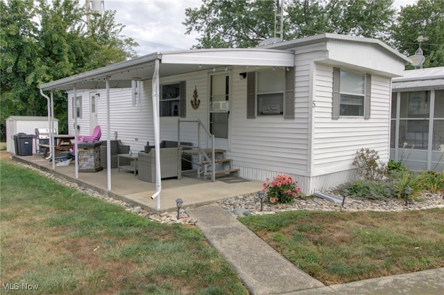 manufactured / mobile home with a front yard and a patio area