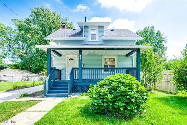 bungalow-style home with covered porch and a front lawn