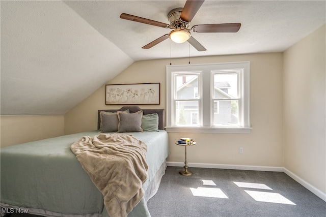 bedroom featuring lofted ceiling, ceiling fan, carpet floors, and a textured ceiling