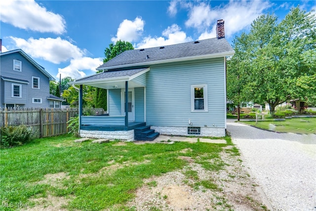 rear view of property featuring a yard