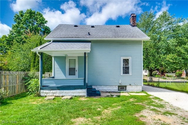 rear view of house featuring a lawn