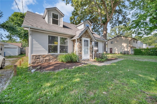 view of front facade featuring an outbuilding, a garage, and a front lawn