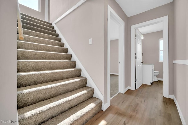 stairs with baseboards and wood finished floors