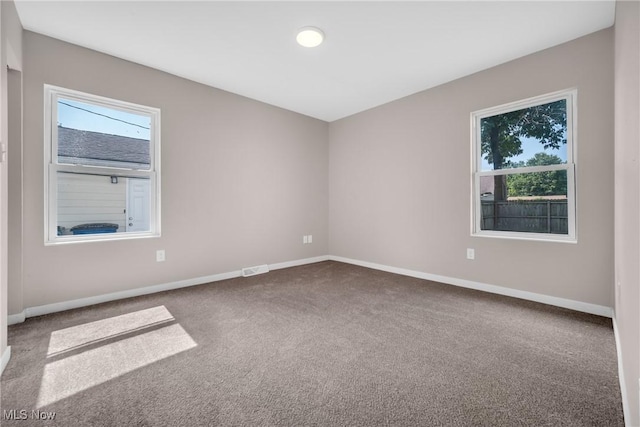 carpeted spare room with baseboards