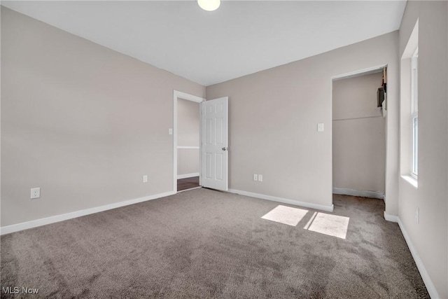 unfurnished bedroom featuring carpet flooring, baseboards, and a closet