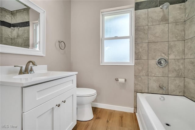 full bathroom with baseboards, shower / washtub combination, toilet, wood finished floors, and vanity