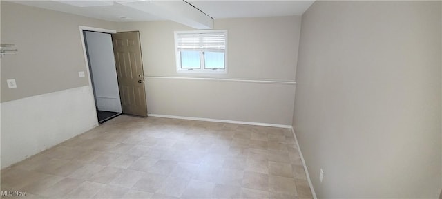 unfurnished room featuring light floors and baseboards