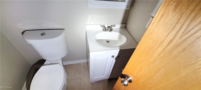 bathroom featuring baseboards, vanity, and toilet