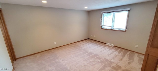 unfurnished room featuring recessed lighting, baseboards, visible vents, and light colored carpet