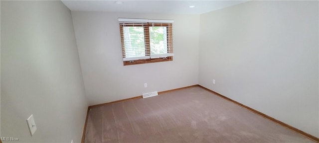 empty room with carpet floors, visible vents, and baseboards