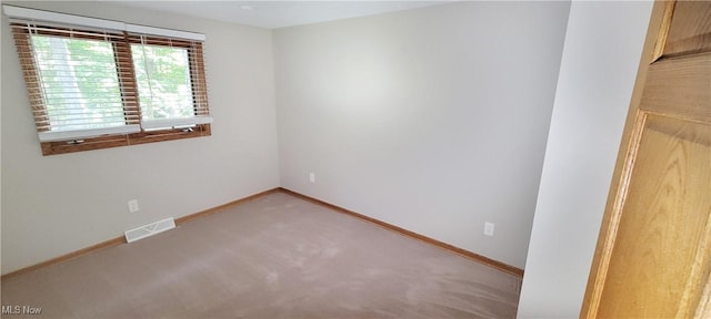 unfurnished room featuring carpet flooring, visible vents, and baseboards