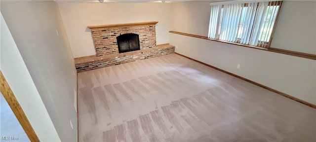 unfurnished living room with a fireplace and baseboards