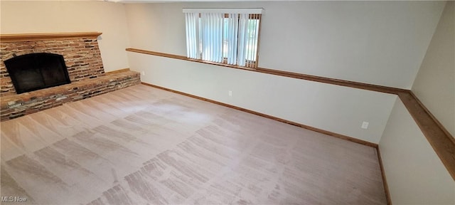 unfurnished living room with carpet, a fireplace, and baseboards