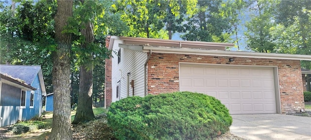 garage featuring concrete driveway