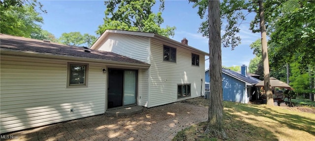 rear view of house featuring a lawn and a chimney