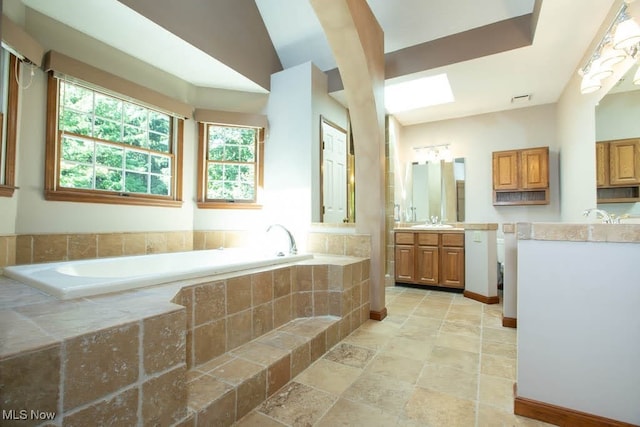 bathroom with tiled tub and vanity