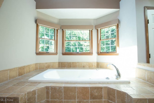 bathroom with plenty of natural light and tiled bath