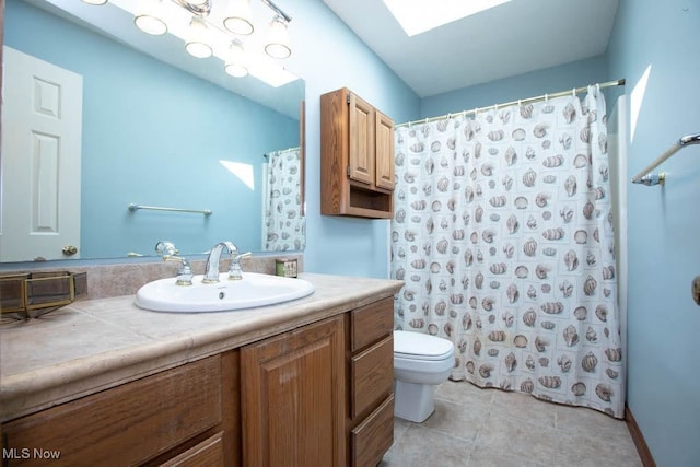 bathroom with tile patterned flooring, walk in shower, a skylight, toilet, and vanity