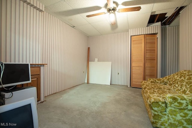 living room featuring ceiling fan and a paneled ceiling