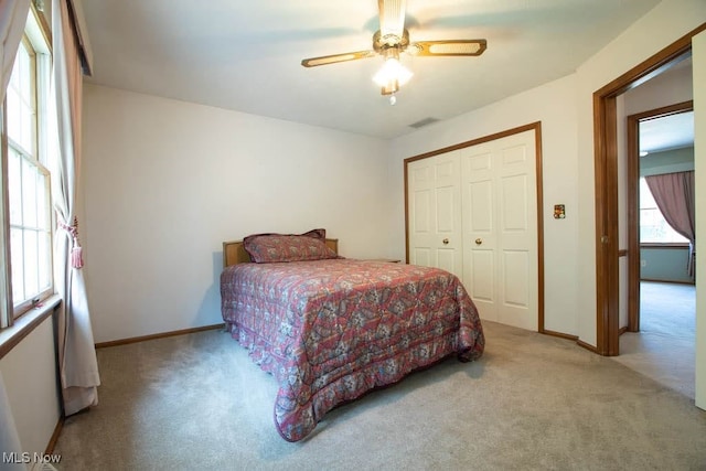 carpeted bedroom featuring a closet and ceiling fan