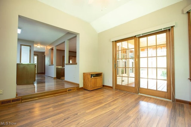 unfurnished room featuring vaulted ceiling and hardwood / wood-style floors