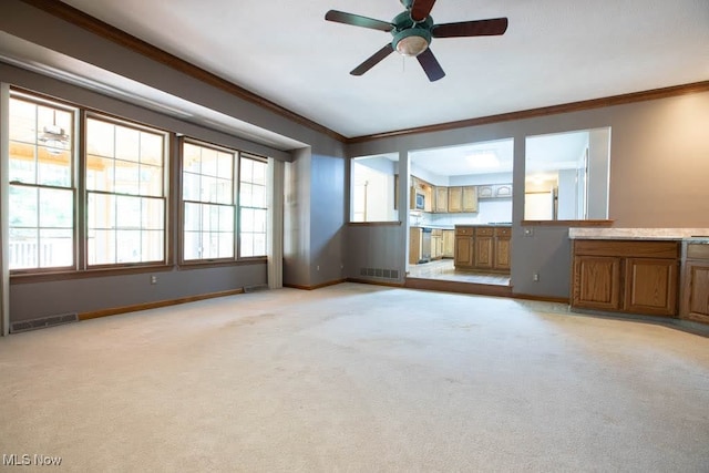 unfurnished living room with ceiling fan, light colored carpet, and crown molding