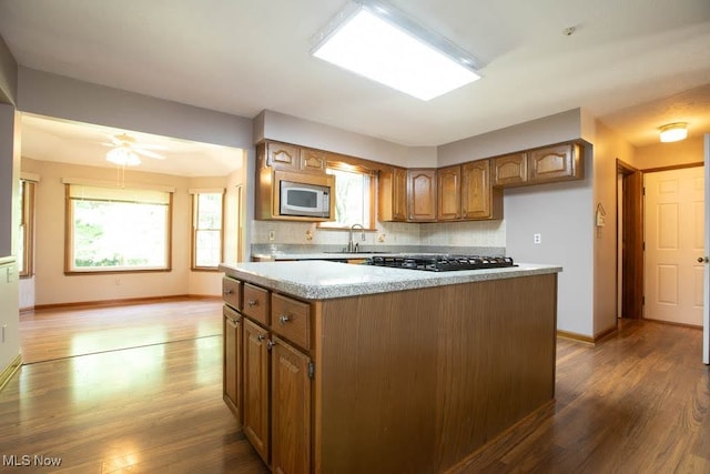 kitchen with ceiling fan, black gas stovetop, stainless steel microwave, and dark wood-type flooring