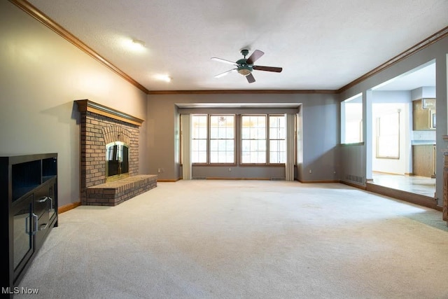 living room featuring ceiling fan, a fireplace, ornamental molding, light colored carpet, and a textured ceiling