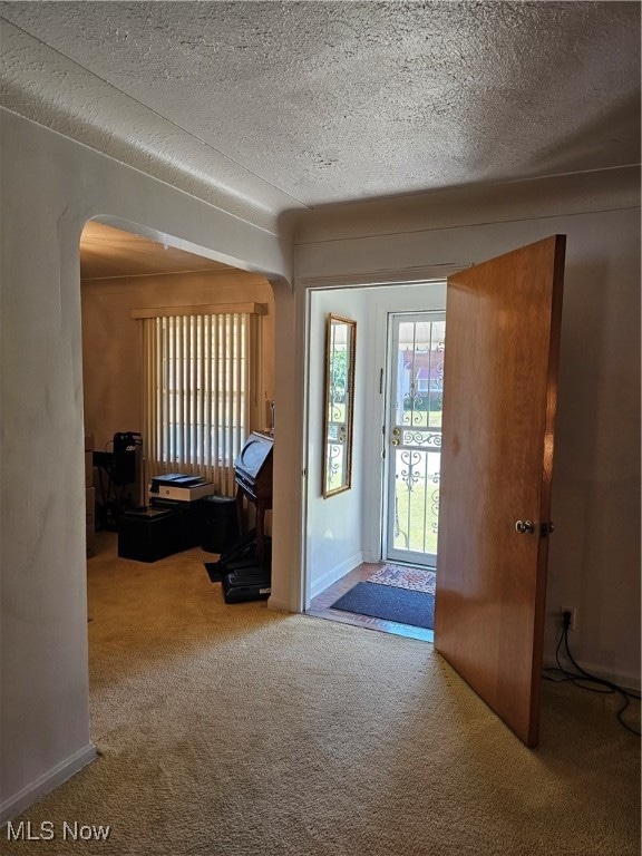 entryway with a textured ceiling and carpet