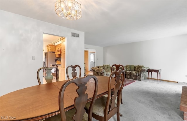 dining space featuring a notable chandelier and carpet floors