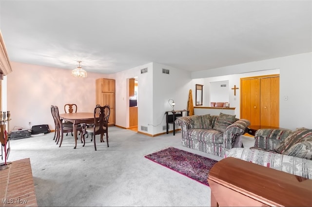 carpeted living room featuring a notable chandelier