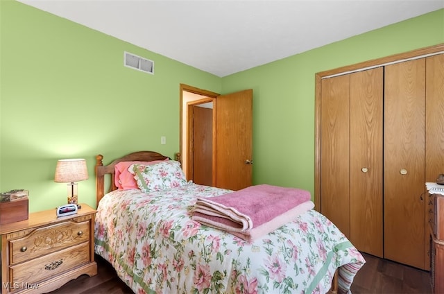 bedroom with dark hardwood / wood-style floors and a closet