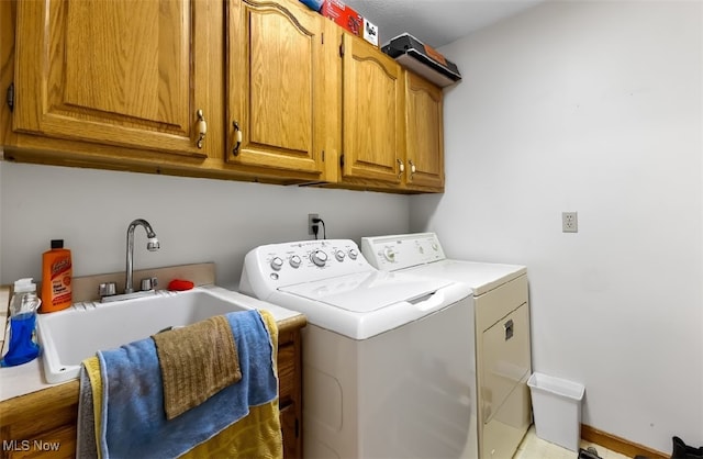 washroom with cabinets, independent washer and dryer, and sink