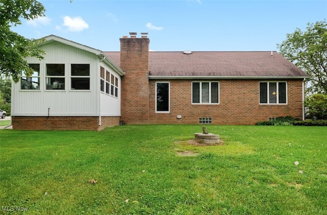 rear view of house featuring a lawn