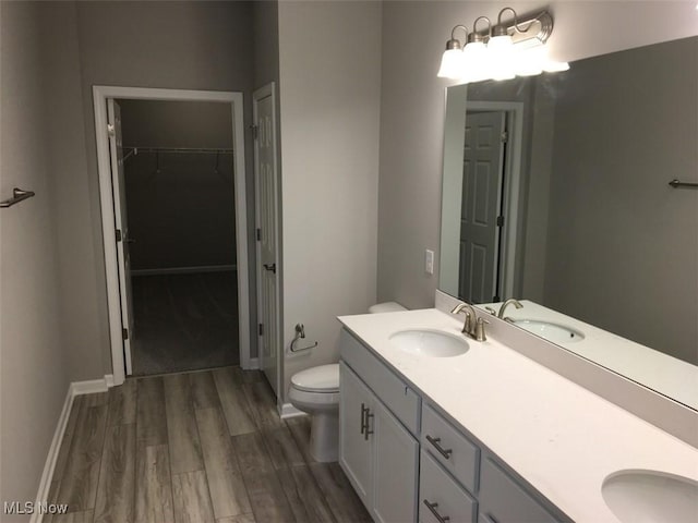 bathroom with hardwood / wood-style floors, vanity, and toilet