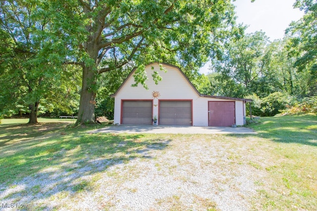 view of home's exterior with an outdoor structure, a garage, and a yard