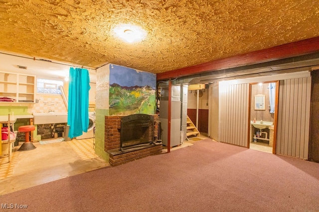 basement with carpet flooring, heating unit, and a fireplace