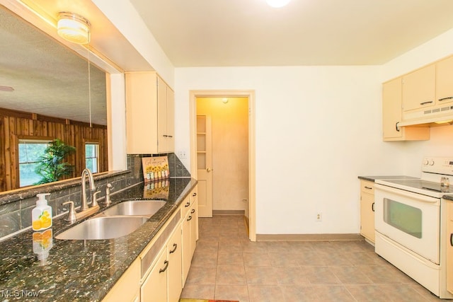 kitchen with dark stone counters, sink, electric range, decorative backsplash, and light tile patterned flooring