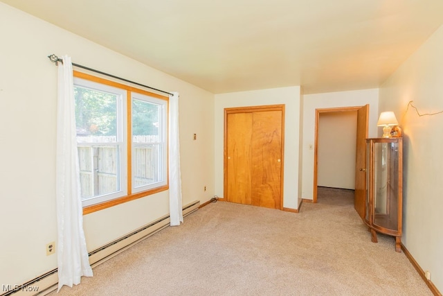 unfurnished bedroom featuring a closet, light colored carpet, and a baseboard heating unit