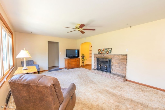 carpeted living room featuring a fireplace, plenty of natural light, and ceiling fan