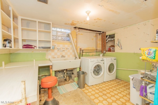 clothes washing area featuring independent washer and dryer and sink