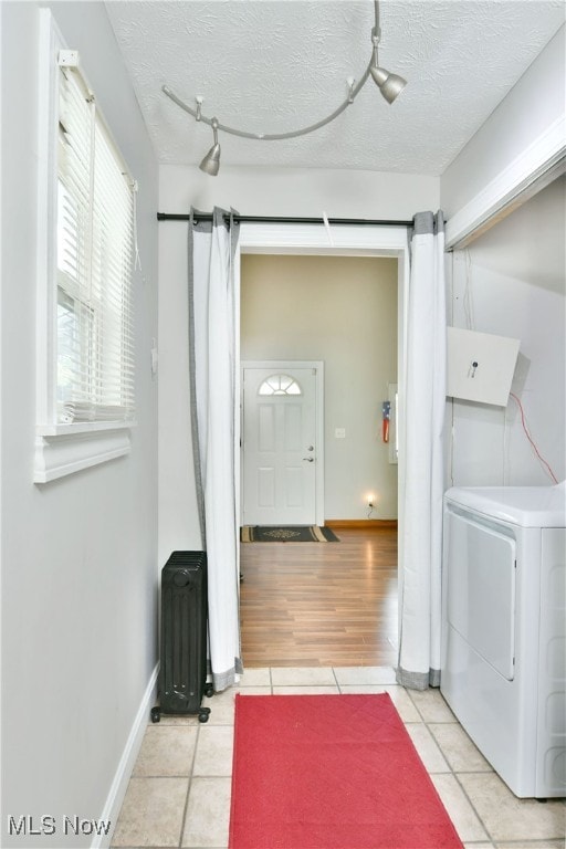 laundry room featuring a textured ceiling, track lighting, washer / dryer, and light tile patterned floors