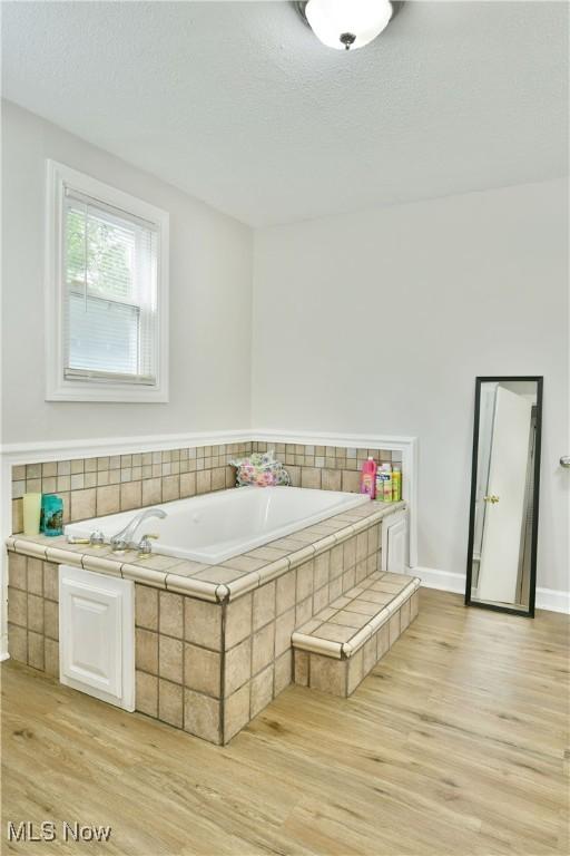 bathroom featuring a textured ceiling and hardwood / wood-style flooring