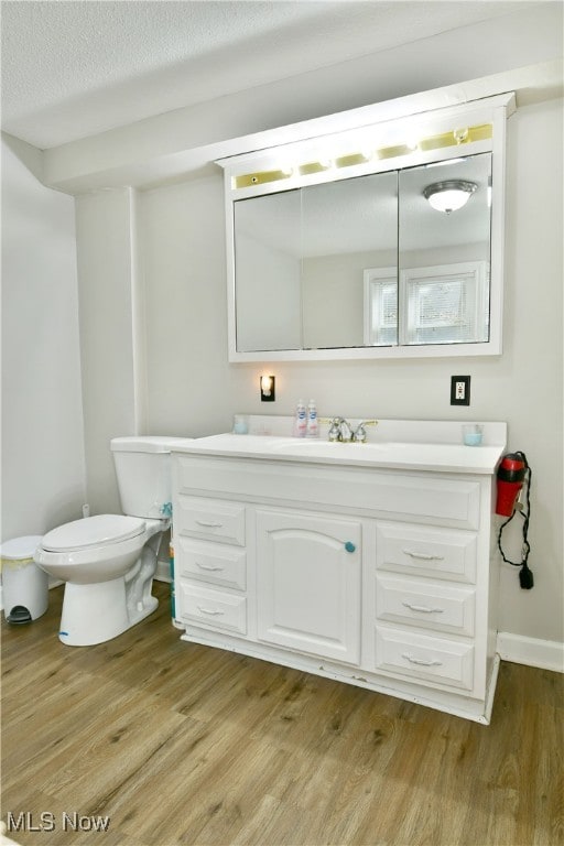 bathroom featuring a textured ceiling, toilet, vanity, and hardwood / wood-style flooring